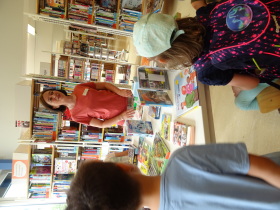 Kinder sitzen am Tisch mit Büchern in Bibliothek