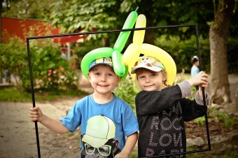 Auf dem Bild sind 2 Kinder mit verschiedenen Hüten zu sehen