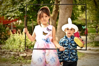 Auf dem Bild sind 2 Kinder mit verschiedenen Hüten zu sehen