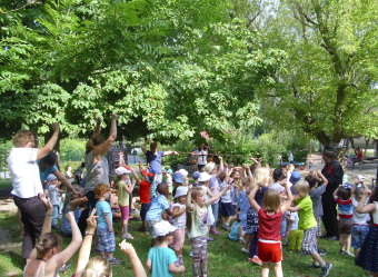 Auf dem Bild sind mehrere Kinder im Garten bei einem Auftritt zu sehen