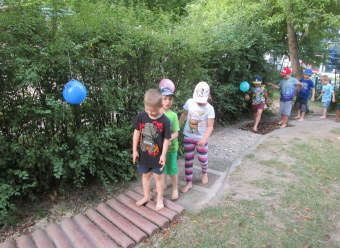 Auf dem Bild sind Kinder auf einem Barfußpfad zu sehen