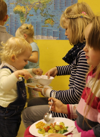 Auf dem Bild sind Kinder beim Essen zu sehen