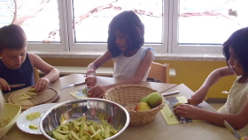 Auf dem Bild sind Kinder bei der Essenszubereitung zu sehen