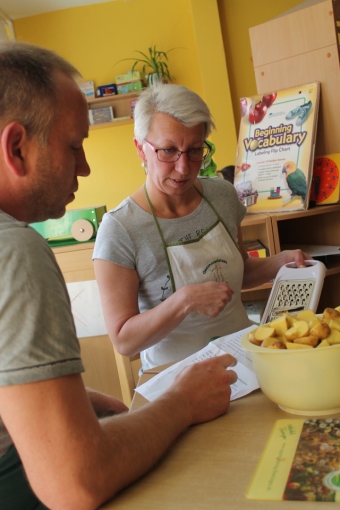 Auf dem Bild sind eine Frau und ein Mann zu sehen, die in einem Rezept nachschauen