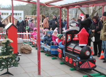 Auf dem Bild ist eine Kindereisenbahn mit den Kindern zu sehen