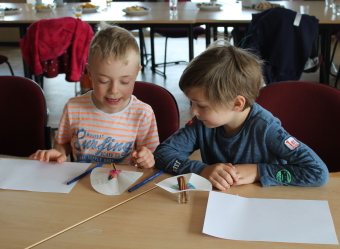 Auf dem Bild sind die Kinder bei einem Experiment zu sehen