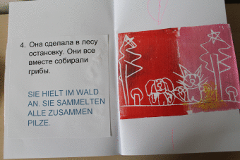 Aufgeschlagenes Buch , auf einer Seite Text auf der anderen Seite ein rotgefärbtes Linoldruckbild