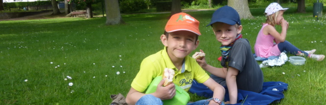 Kinder frühstücken im Park bei schönem Wetter