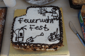 Sahniger viereckiger Kuchen mit einer Feuerwehr aus Schokoguss