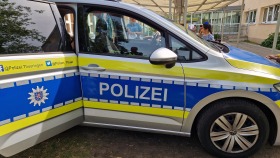 Polizeiauto Kombi steht mit offener Tür im Garten des Kindergartens, die Aufschrift auf der Seite ist zu sehen